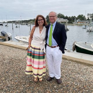 Dr. Ball and his wife dressed up and posing in front of the water