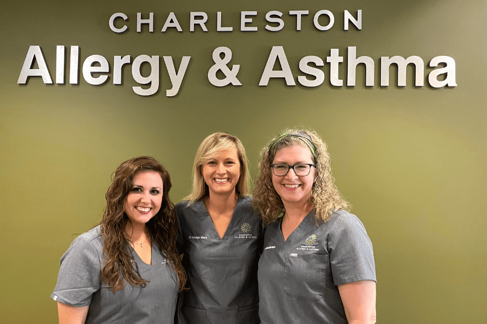 Three woman doctors of Charleston Allergy standing in front of the office sign