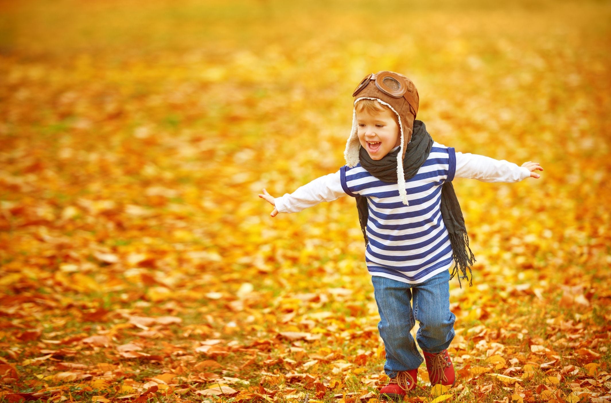 Young boy playing in leaves