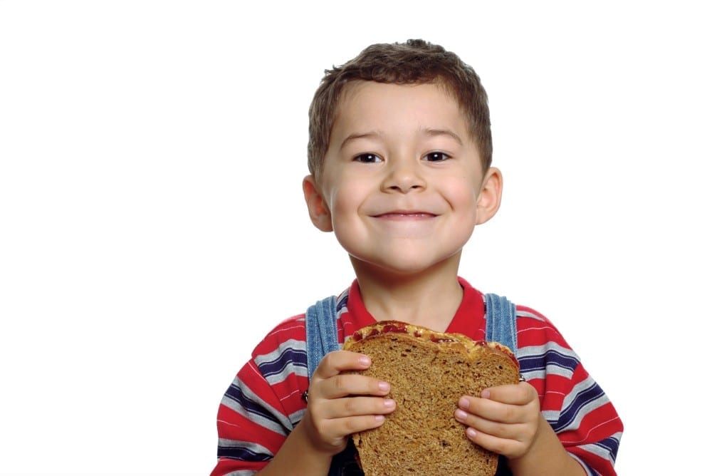 Child eating peanut butter and jelly sandwich