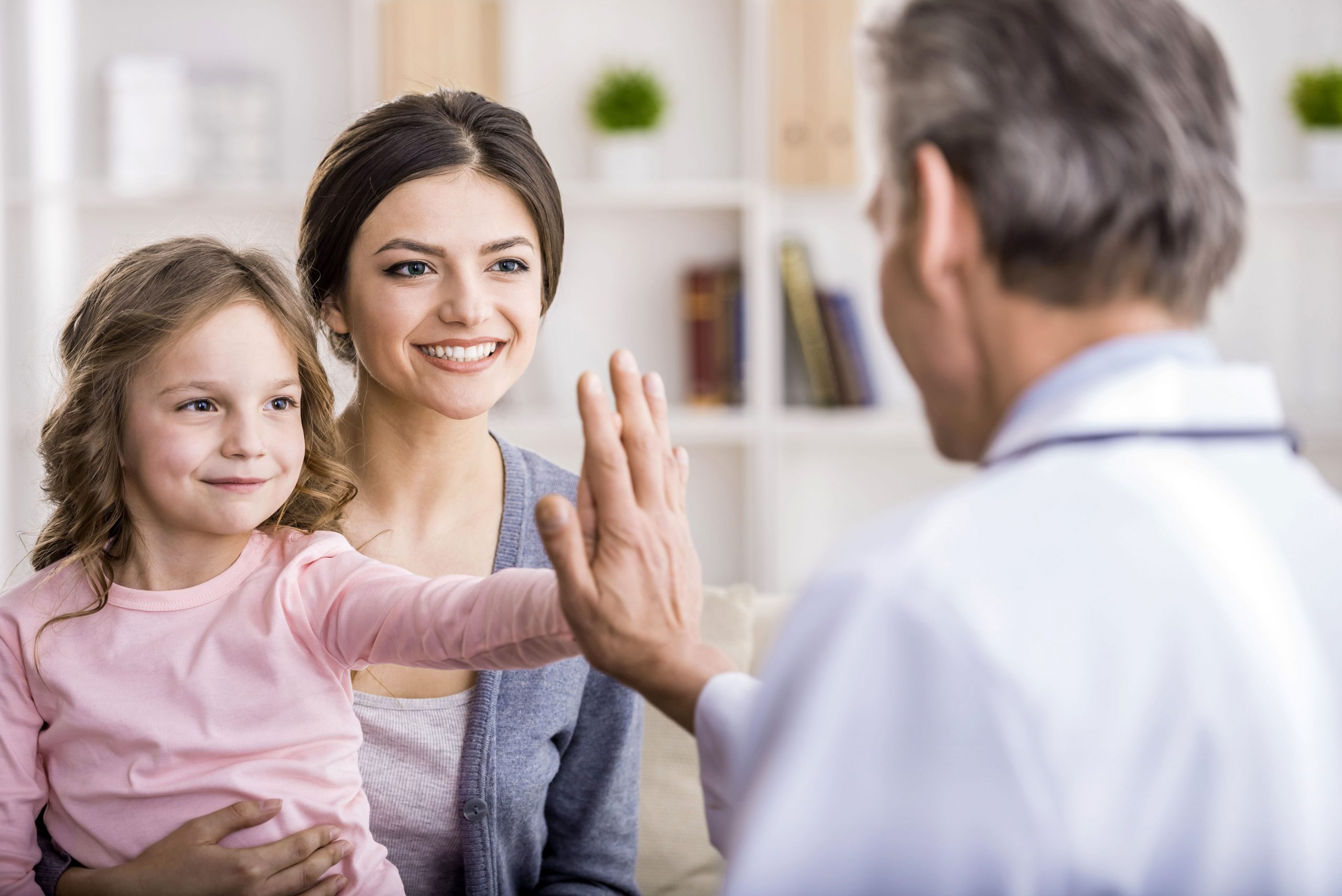 doctor giving high five to mother and daughter