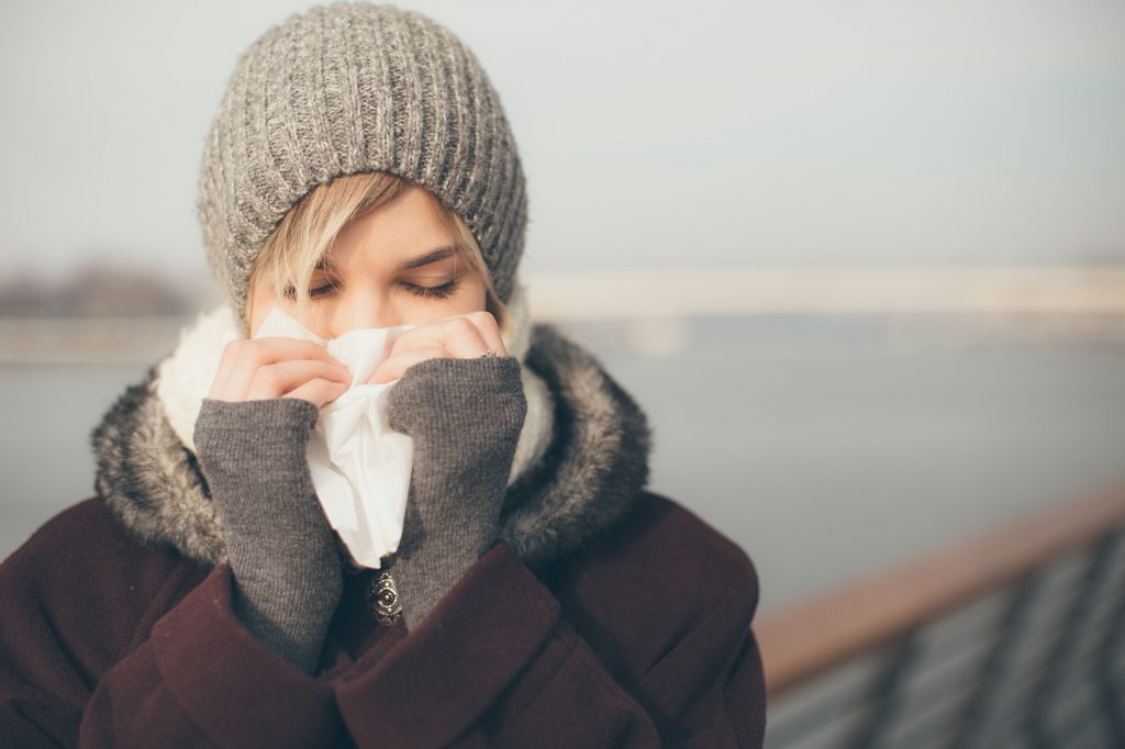 Woman in the cold blowing her nose