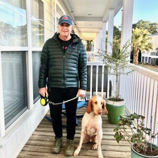 Dr. Harper posing on his porch with his dog Gabe