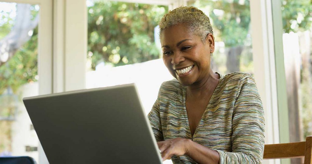 Smiling woman using laptop.|Smiling woman using laptop.