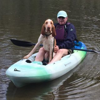 Dr. Harper kayaking on the water with his dog named Gabe