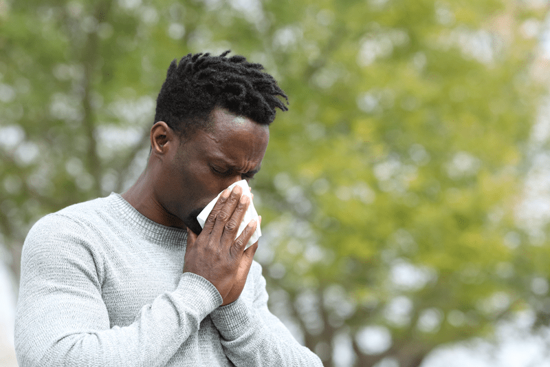 Man sneezing into tissue