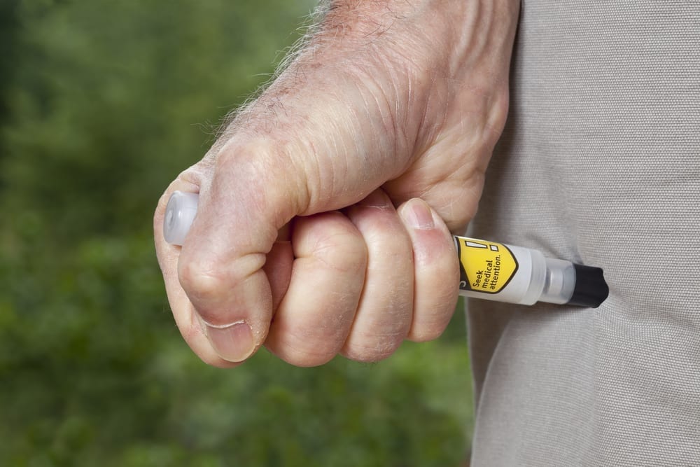 Person injecting leg with EPI pen