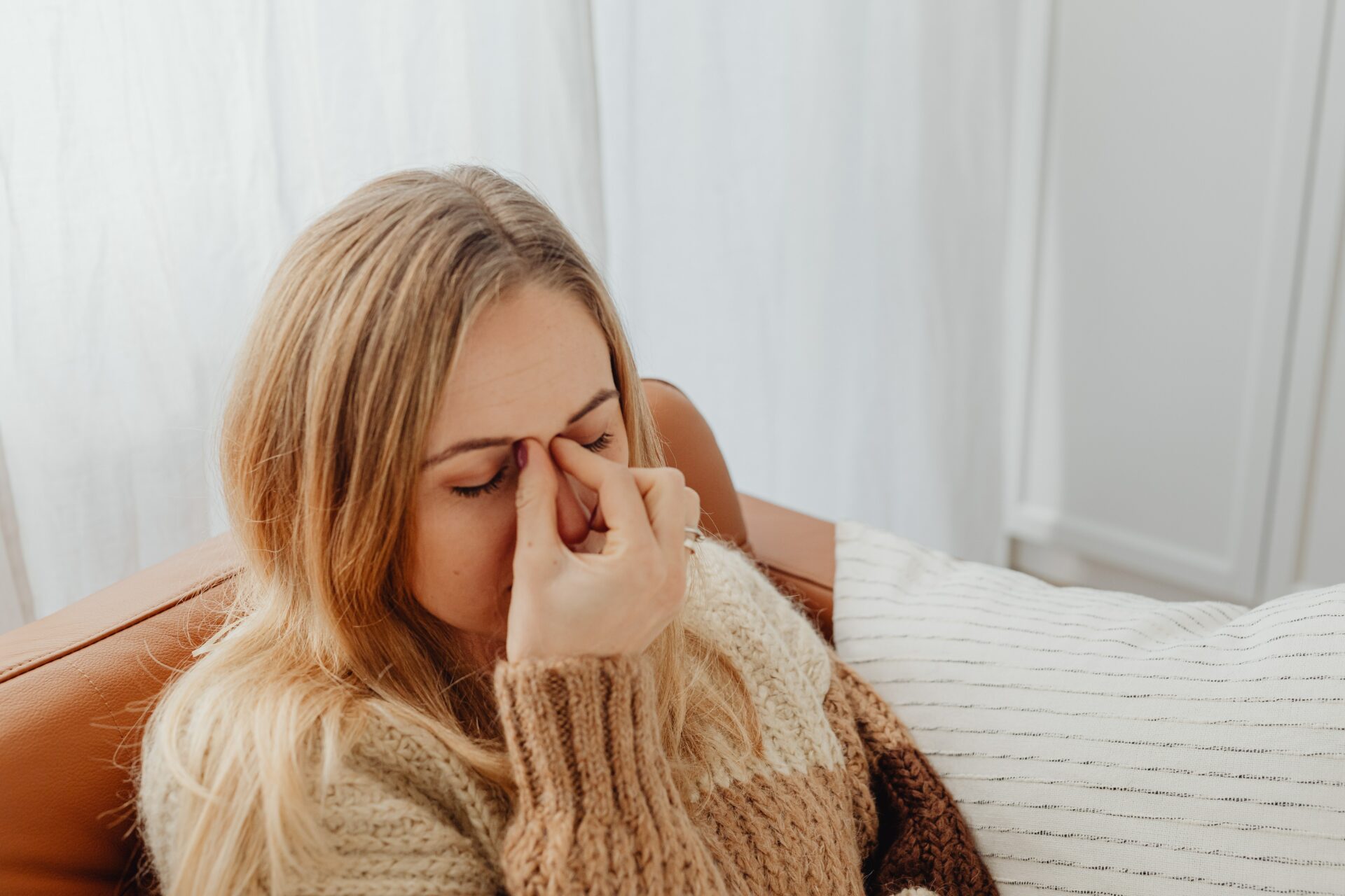 woman pinching bridge of her nose because she has a sinus infection