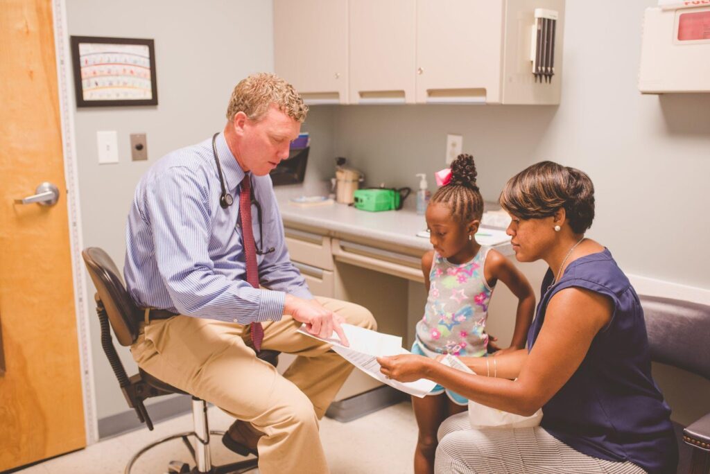 Charleston Allergy and Asthma doctor explaining papers to mother and daughter during their first appointment