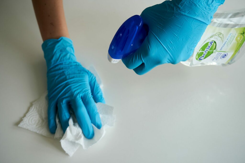 Cleaning countertops with paper towel, spray and gloves